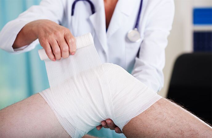 doctor wrapping the knee joint with osteoarthritis